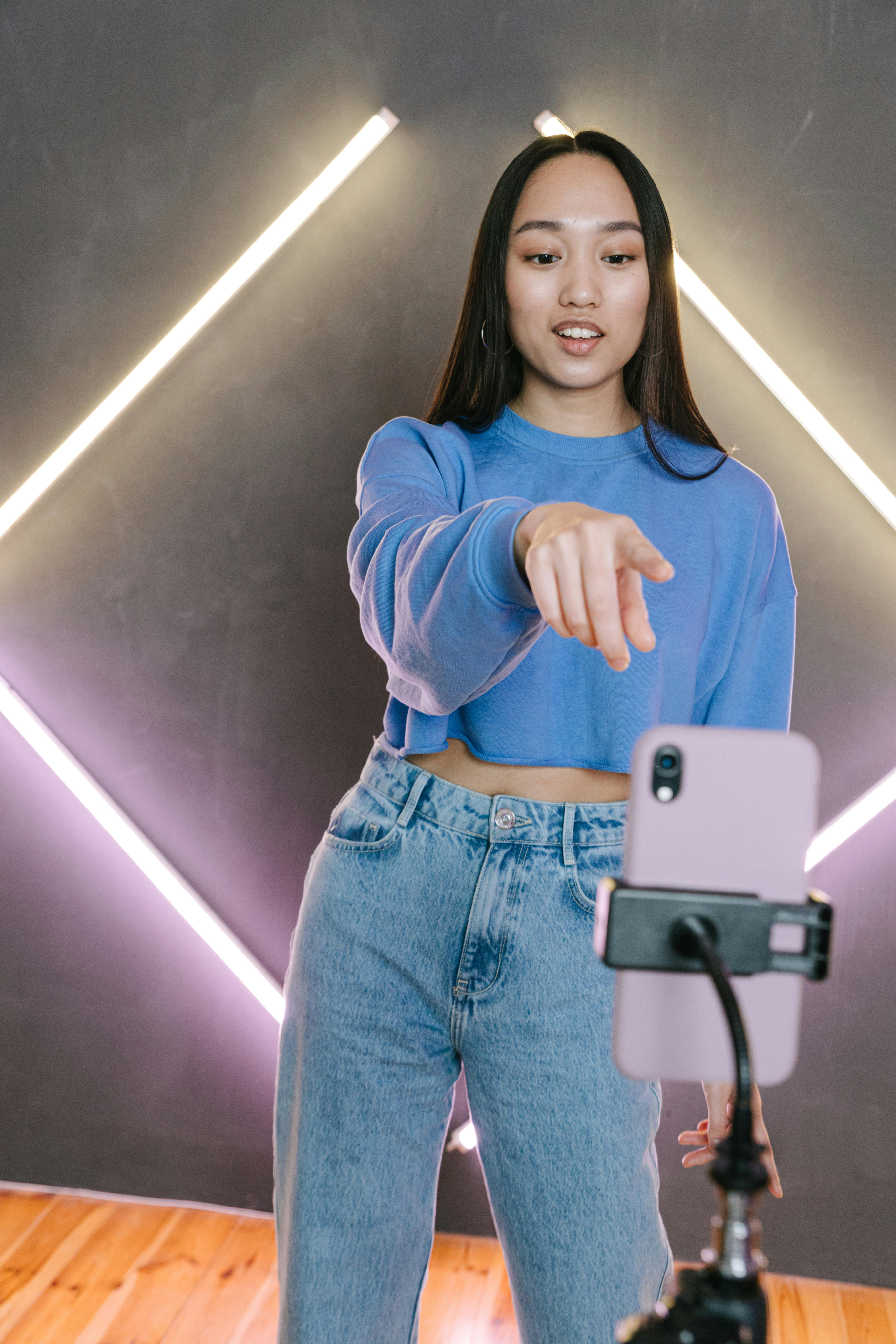 Mujer joven en ropa azul tomando una selfie con un teléfono